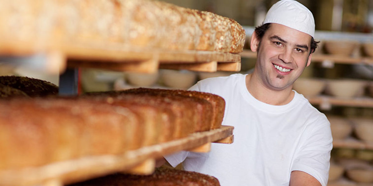 brot, bäcker, bäckerei, backwaren, mensch, person, backstube, regal, brotregal, backen, handwerk, handwerklich, gärkörbe, produktion, herstellung, qualität, verkauf, verkaufen, laib, brotlaib, lebensmittel, sortiment, genuss, genießen, lecker, gebacken, angebot, ernährung, ballaststoffe, gesund, gesundheit, weizen, getreide, korn, kruste, knusprig, nahrungsmittel, rund, kaufen, mehl, frisch, frische, holzregal, mann, zufrieden, lachen, lächeln, 30-40