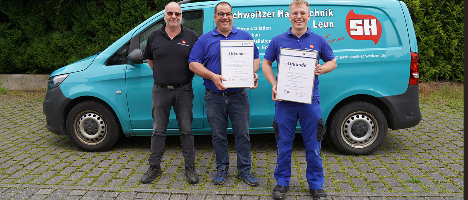 Gruppenfoto, von rechts: Geschäftsführer Claus-Peter und Henner Schweitzer, sowie Maximilian Schweitzer mit Urkunde stehend vor dem Firmenbus.